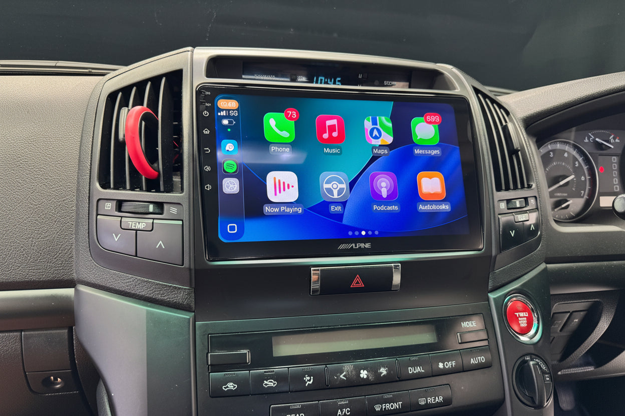 Car dashboard with an infotainment system displaying various app icons.